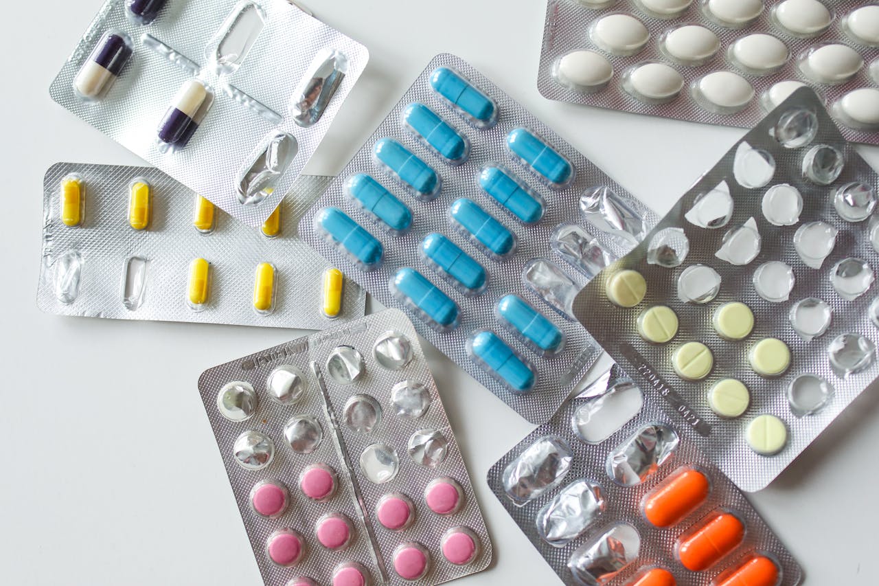 hero-img-01 Colorful assortment of pills and capsules in blister packs for healthcare and medication usage.